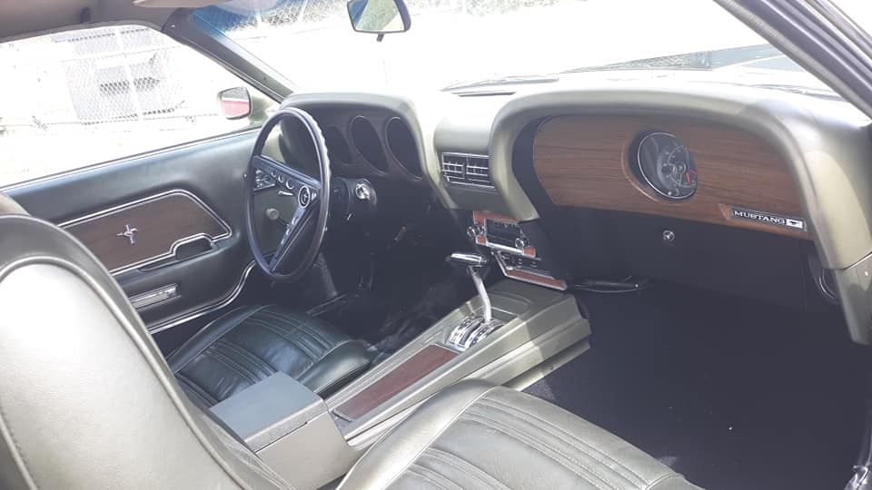 The interior of a ford mustang with a steering wheel and dashboard.