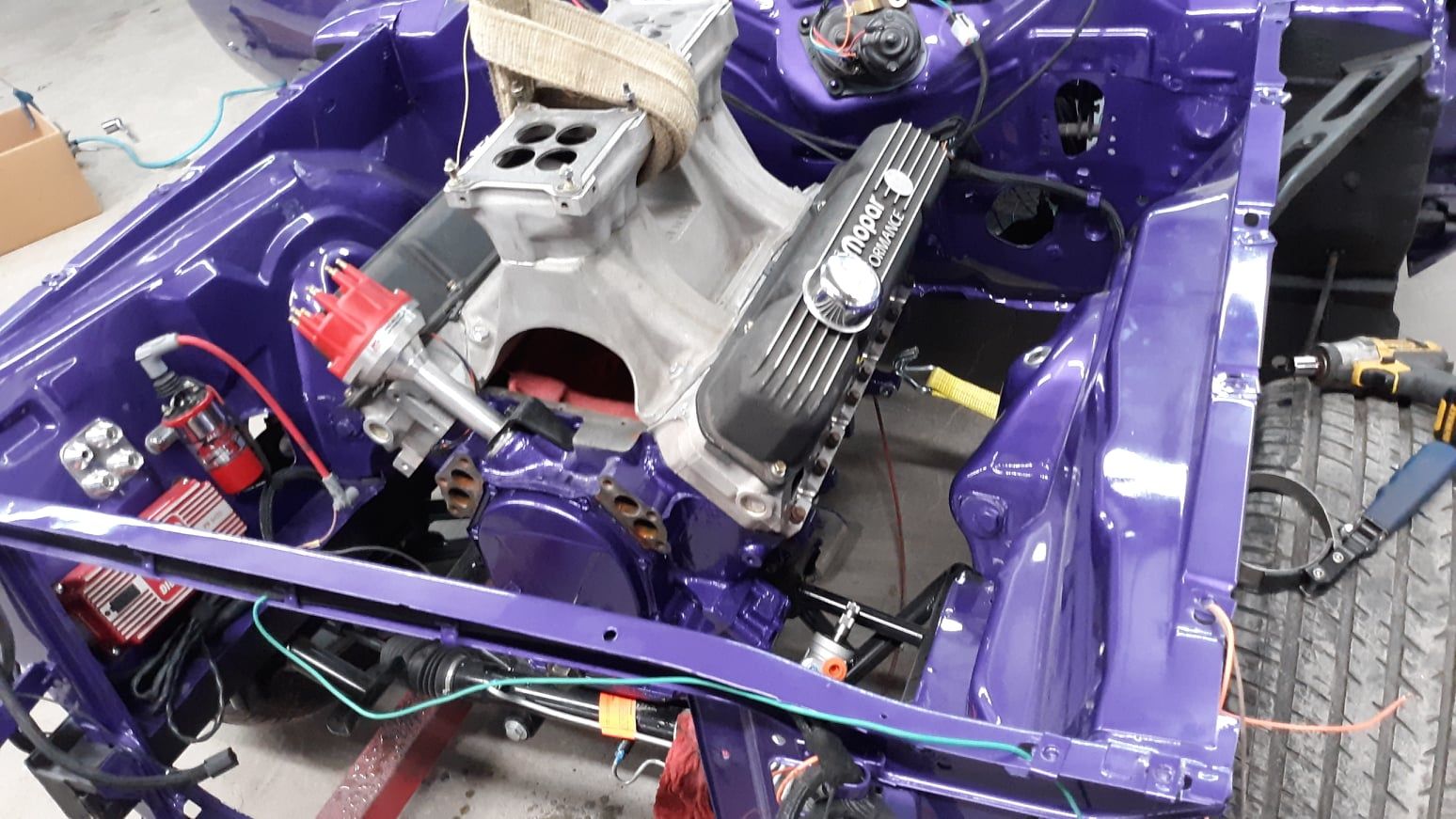 A purple car with a engine in it is being built.
