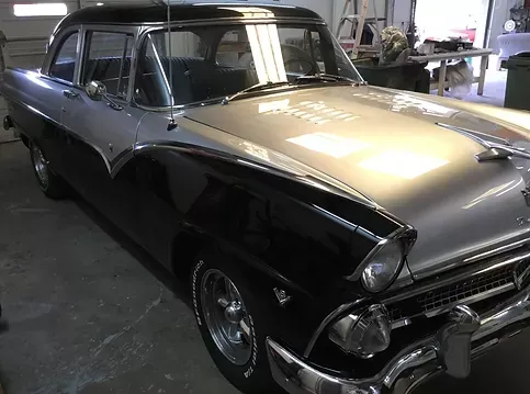 A black and silver car is parked in a garage.