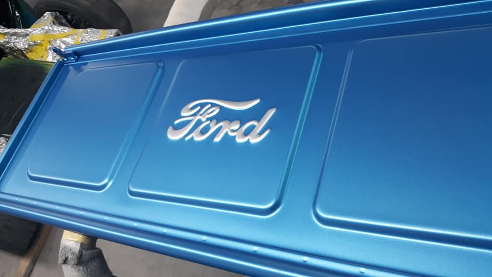 A blue ford tailgate is sitting on a table.