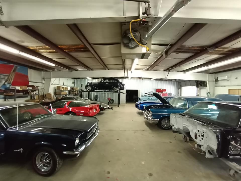 A row of cars are parked in a garage.