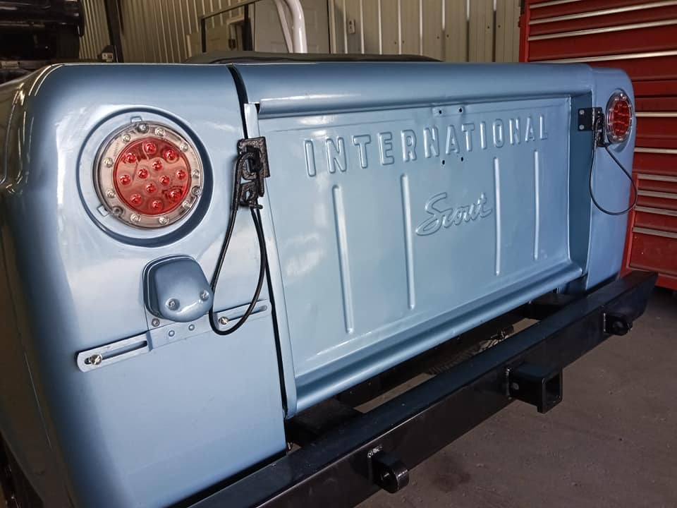 A blue international scout truck is parked in a garage