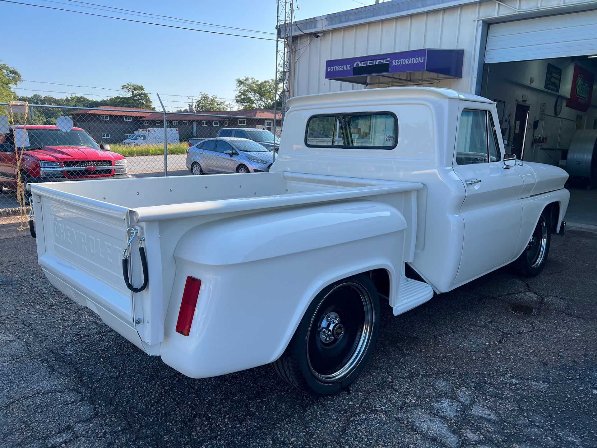 White Chevrolet pickup truck parked outside a building with a garage door.