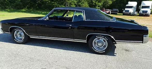 A black car is parked on the side of the road.