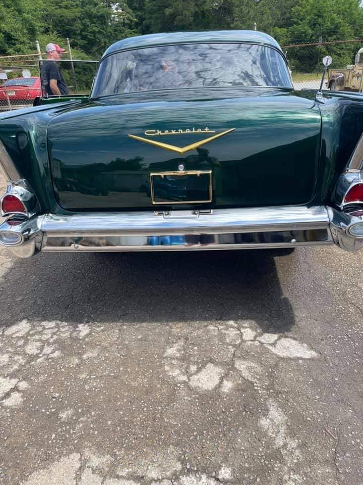 A green chevrolet is parked in a parking lot.