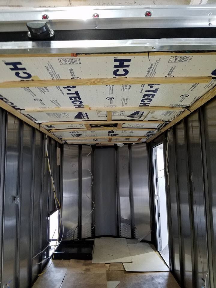 Empty cargo trailer interior with insulated ceiling panels and metal walls