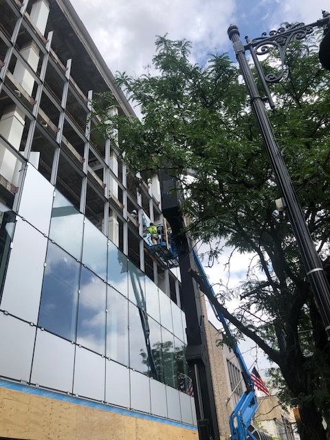 A man is cleaning the windows of a building with a crane