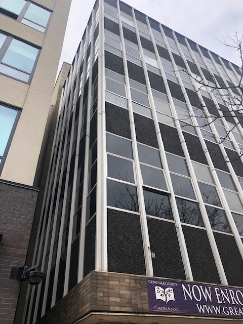 A building with a purple sign that says now enroll