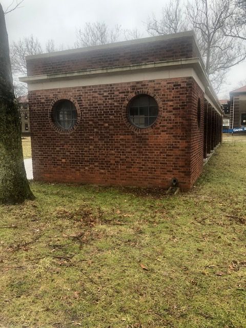 A brick building with two round windows on the side of it