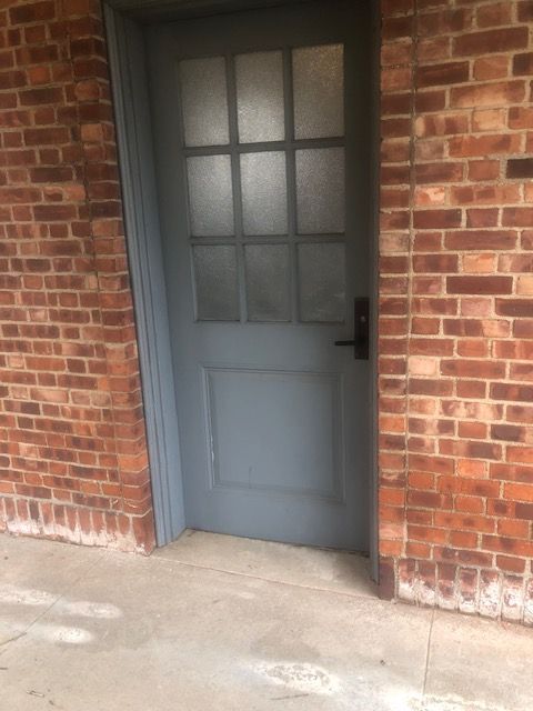 A brick building with a blue door and a glass window
