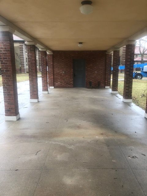 A brick building with a covered porch and columns