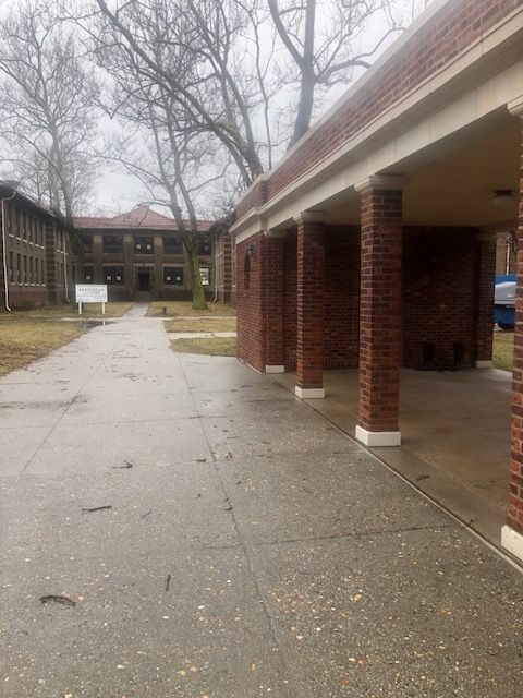 A brick building with a covered walkway leading to it