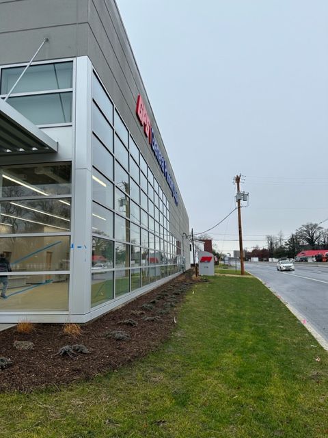 A large building with a lot of windows and a red sign on it