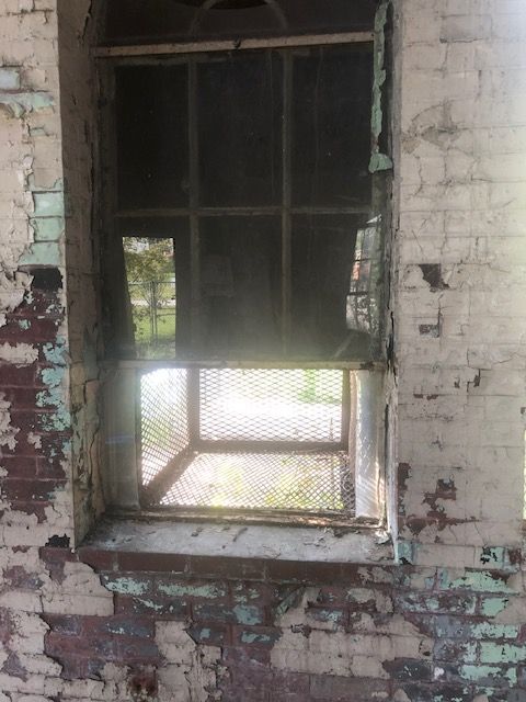 A window in a brick building with a fence around it