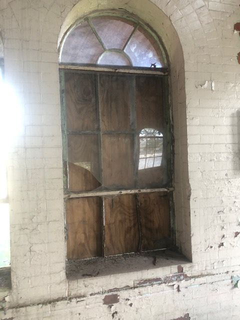 A brick wall with a broken window in it