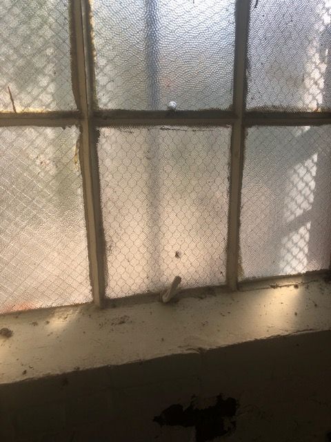 A close-up of a window with a chain link fence around it