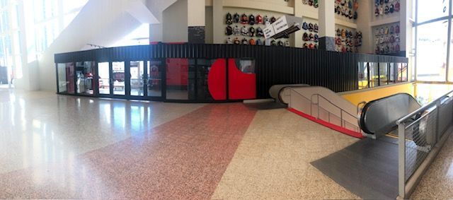 A large empty room with an escalator in the middle of it