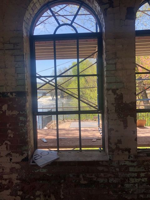 A large window in a brick building with scaffolding behind it