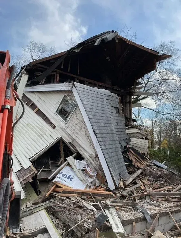 Collapsed house with a collapsed roof and piles of debris