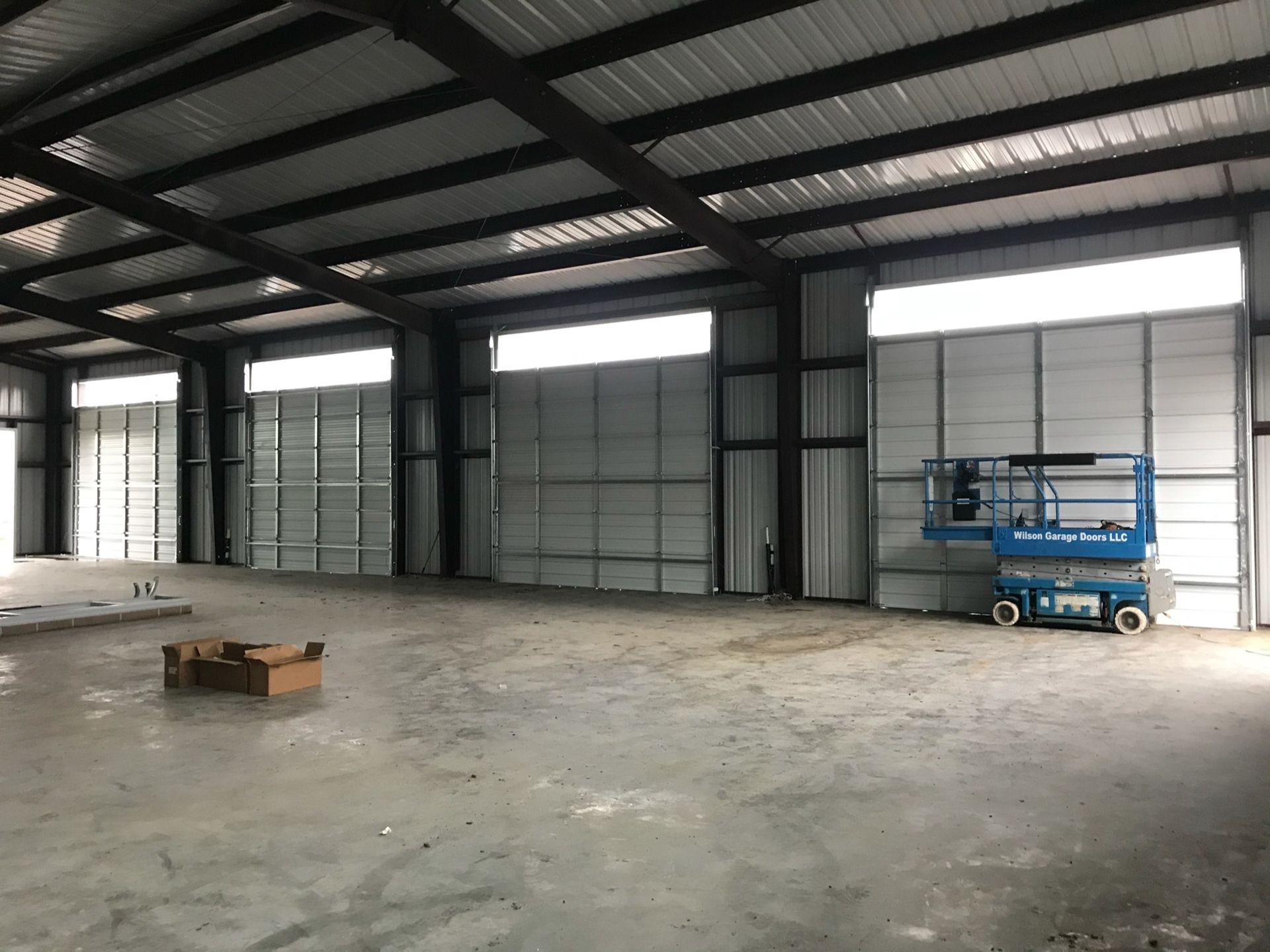 A red truck is parked in front of a white garage door