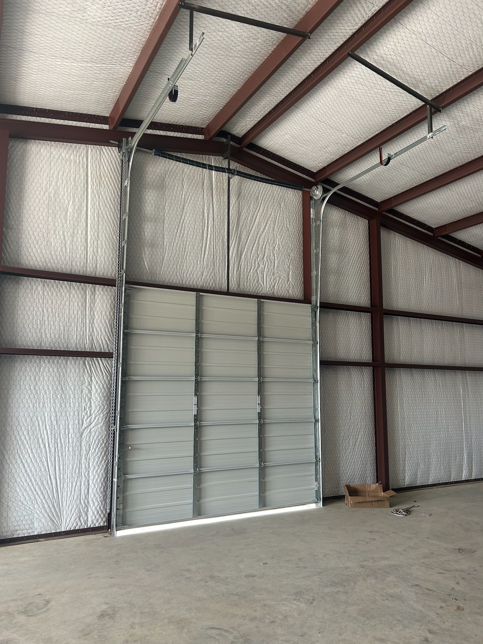 An empty warehouse with a large garage door open.
