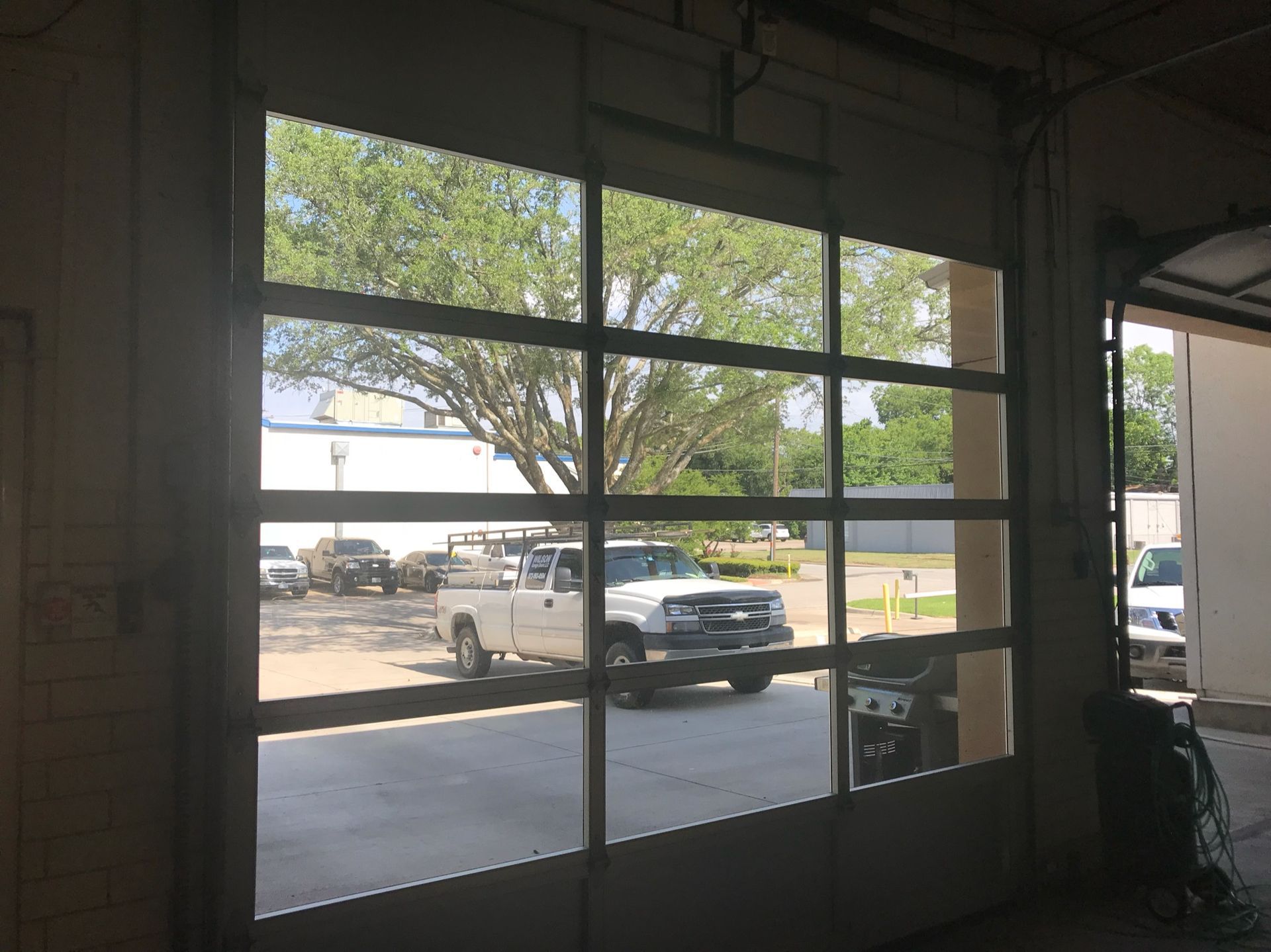 A truck is parked in a parking lot in front of a garage door.