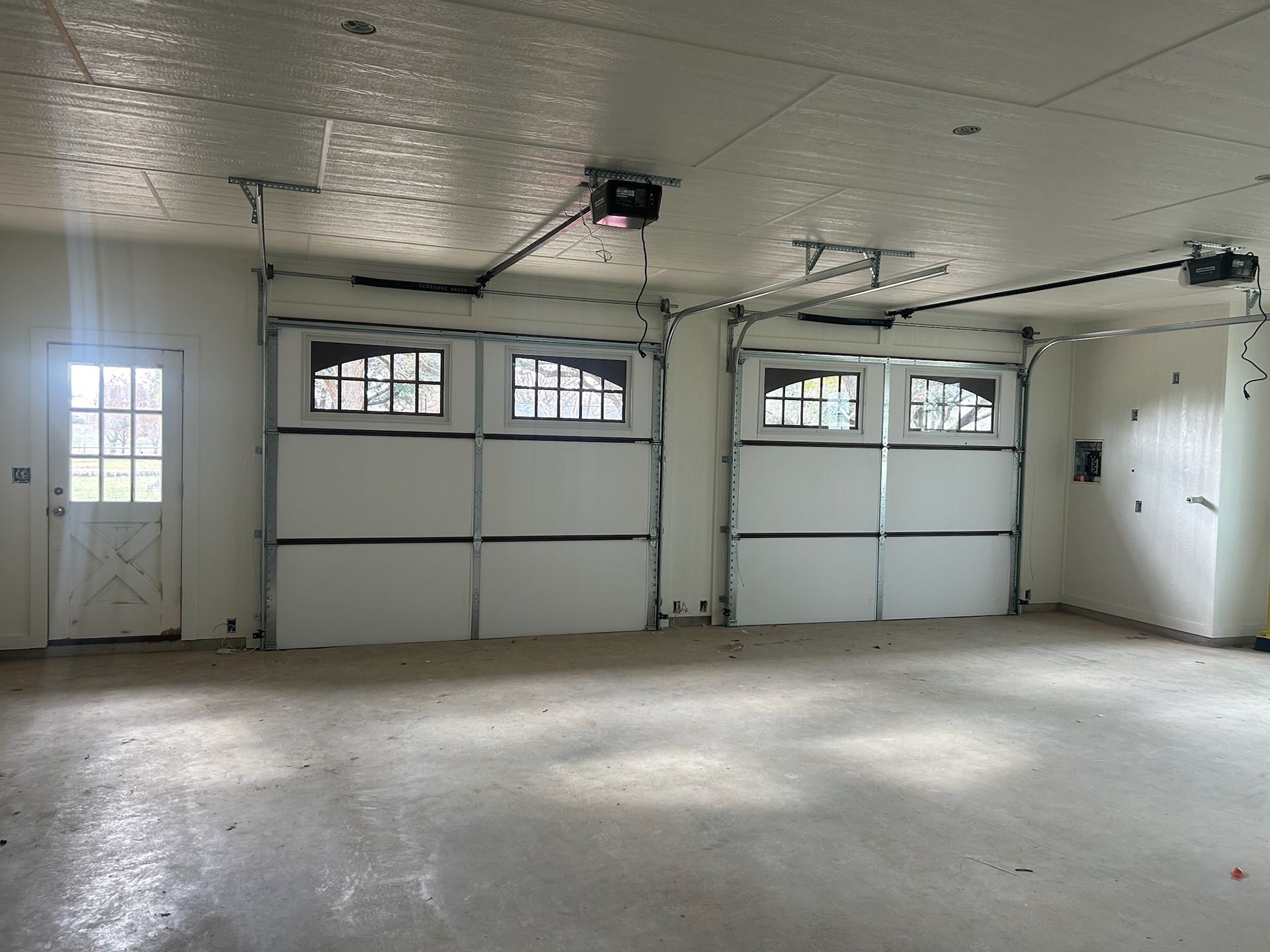 An empty garage with a garage door open and a window