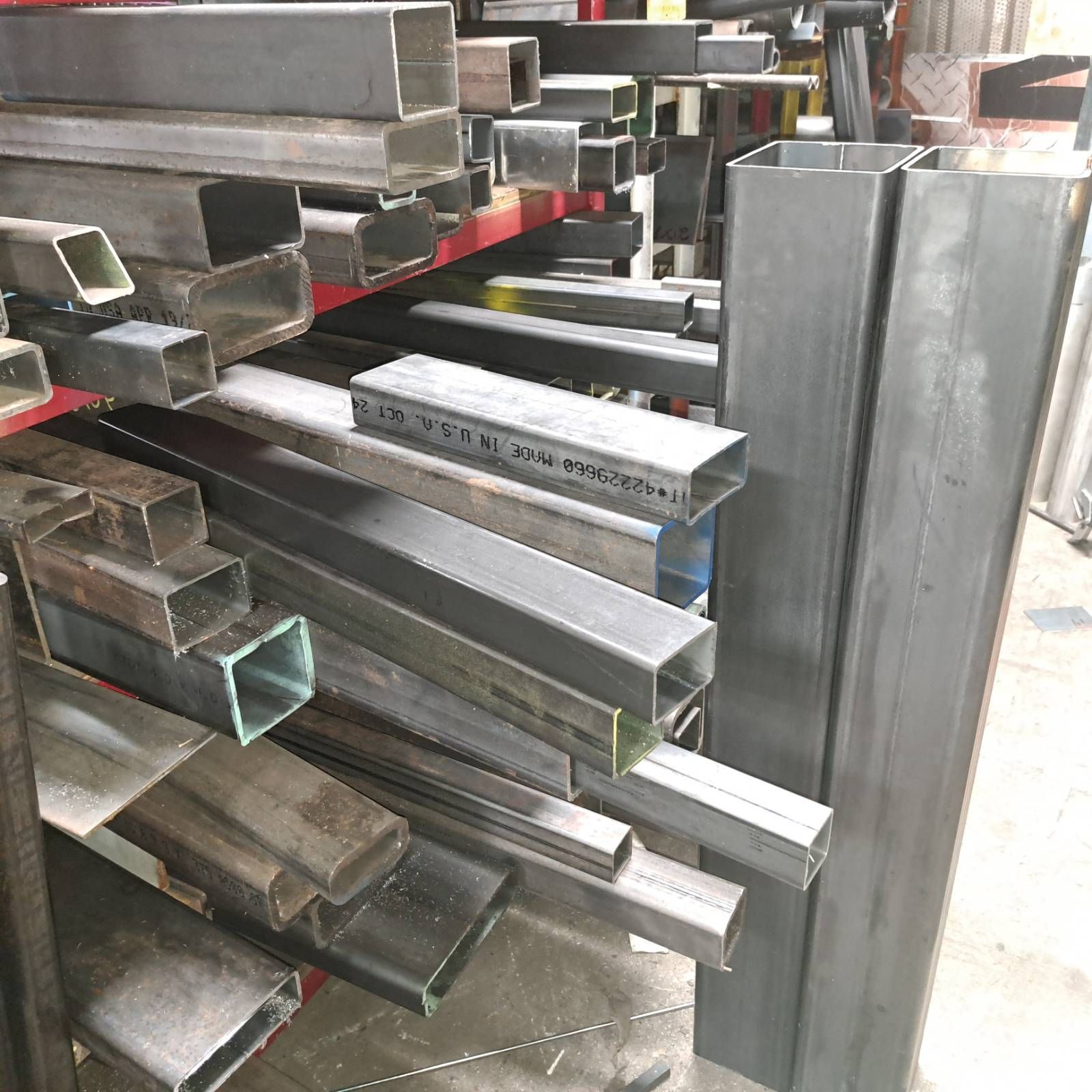 A bunch of metal pipes are stacked on top of each other on a shelf.