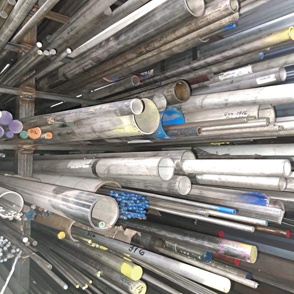 A bunch of metal pipes are stacked on top of each other on a shelf.
