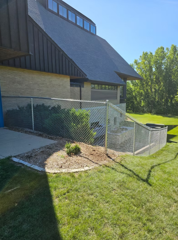 A chain link fence is in front of a building
