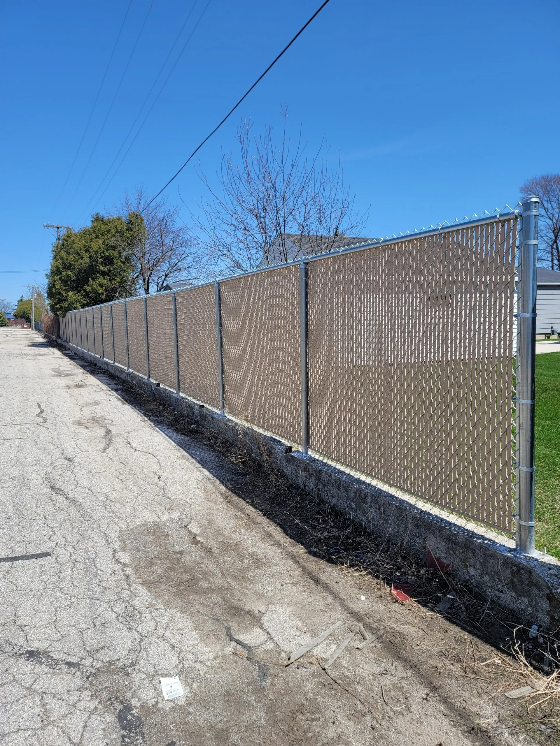 A fence is along the side of a dirt road.