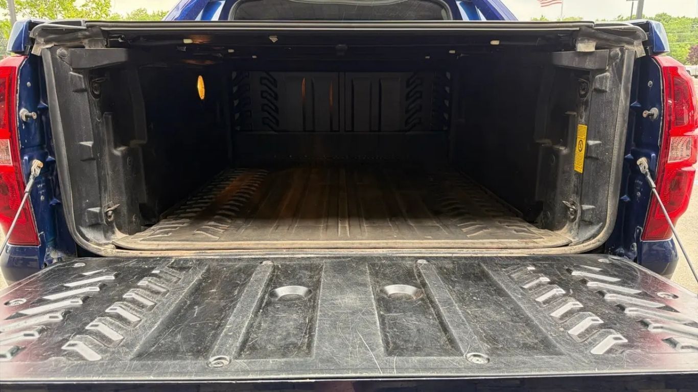 Open pickup truck bed with tailgate lowered and a textured liner inside, viewed from the rear.