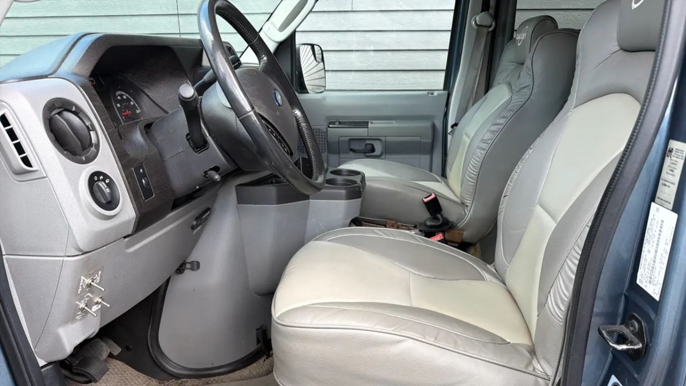 Car interior with gray leather front seats, steering wheel, dashboard, and center console.