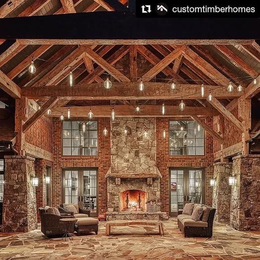 Rustic outdoor living space with fireplace, exposed beams, string lights, and seating.