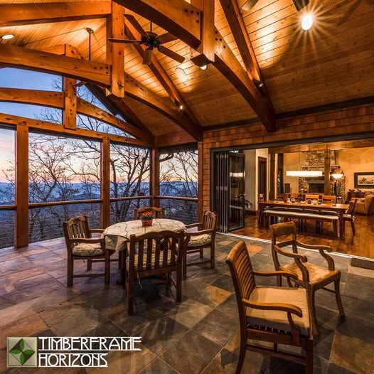 Outdoor seating area with mountain view; wooden beams, slate tile, and open access to a dining room.
