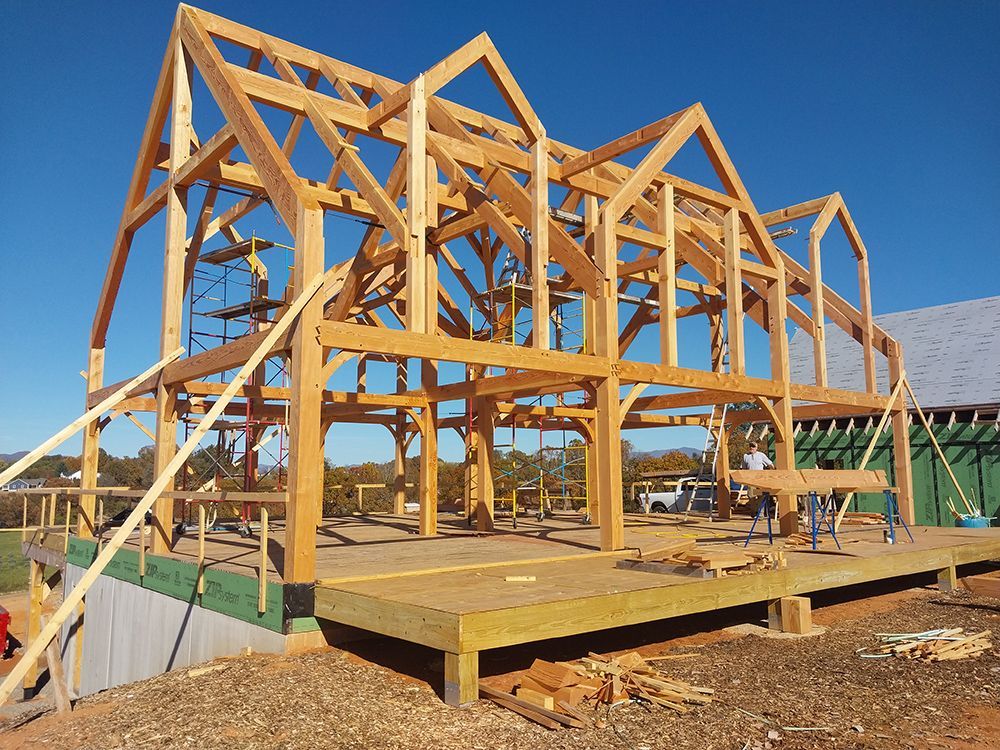 Wooden timber frame of a building under construction, on a sunny day.