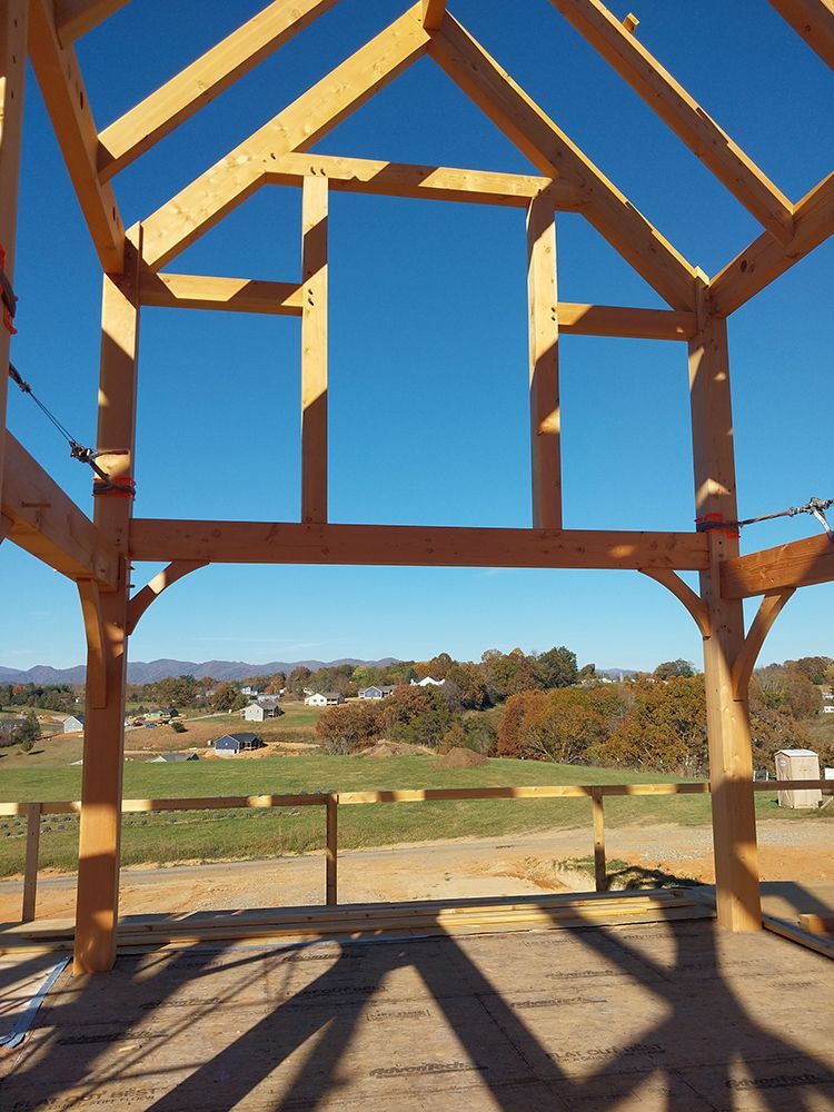 Wooden frame of a building under construction, blue sky background.