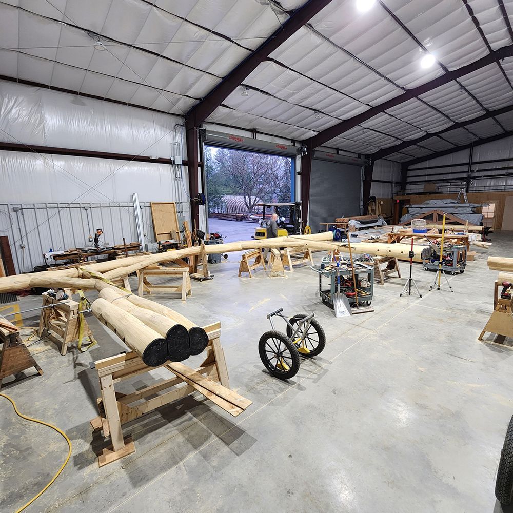 Interior of a workshop with lumber and tools, including a bicycle.