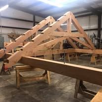 Wooden roof trusses being built in a workshop.