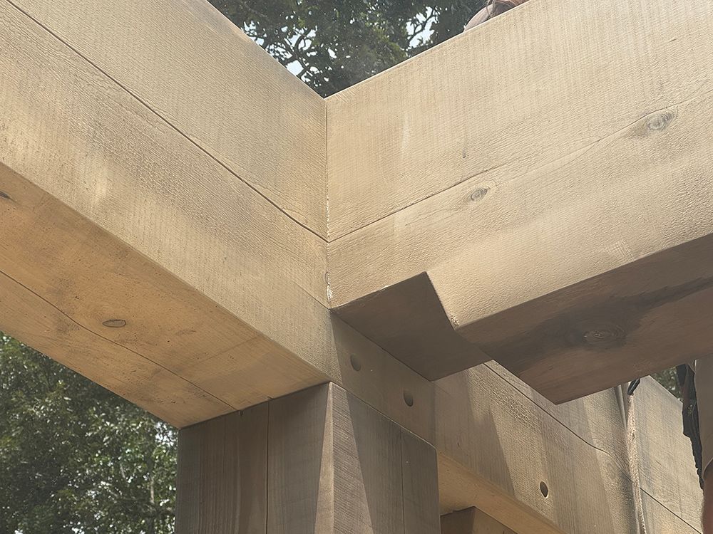 Wooden beams forming a corner joint, outdoors.