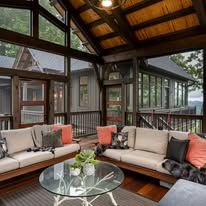 Covered outdoor living space with sofas, glass coffee table, and views.