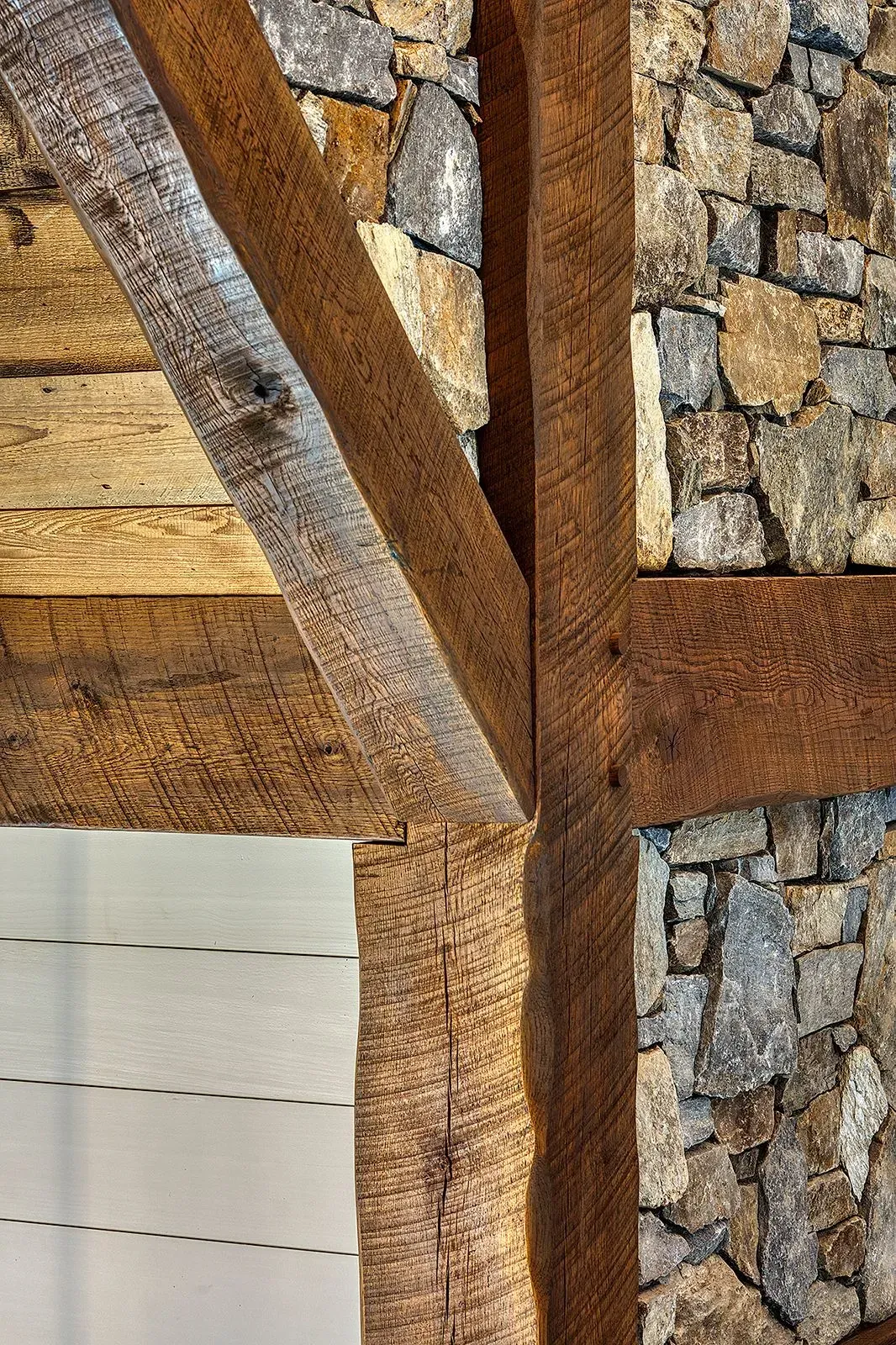 Rustic wooden beams joined with stone wall background.