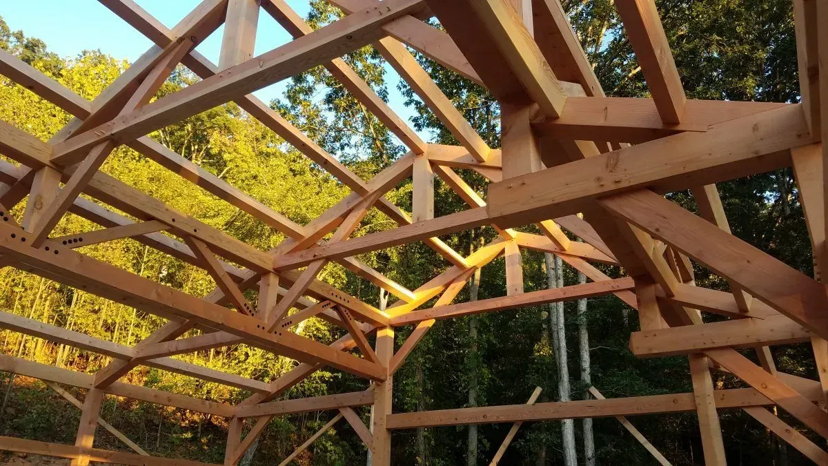 Wooden timber frame construction in progress, outdoors.
