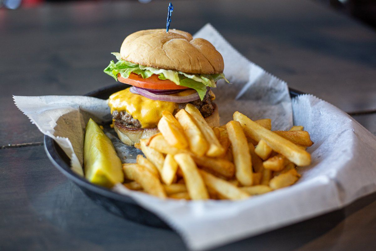 A hamburger and french fries on a plate on a table.