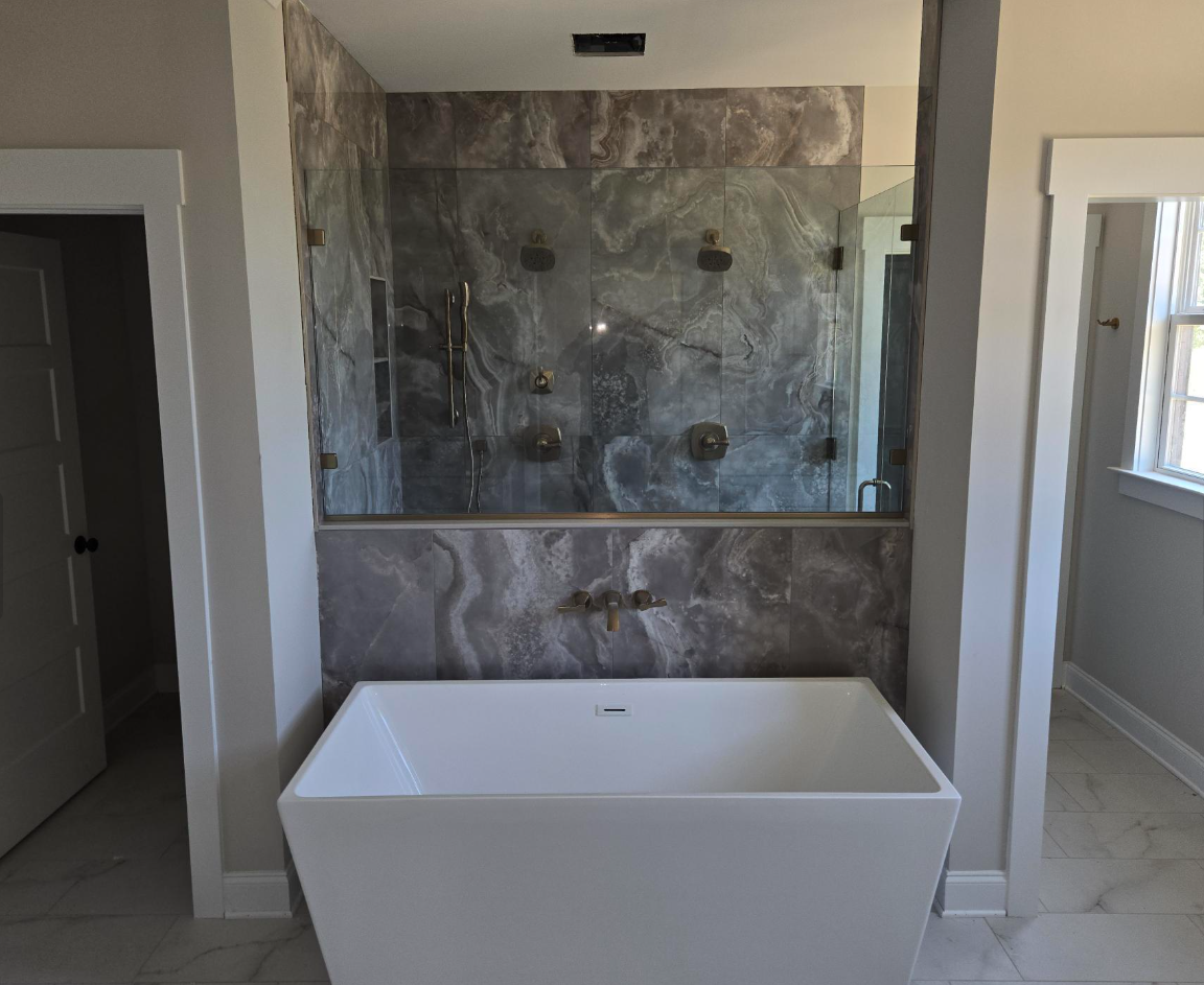Modern bathroom with a freestanding white tub and tiled walk-in shower behind it