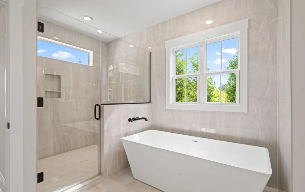 Bright modern bathroom with walk-in shower, freestanding tub, and window letting in daylight