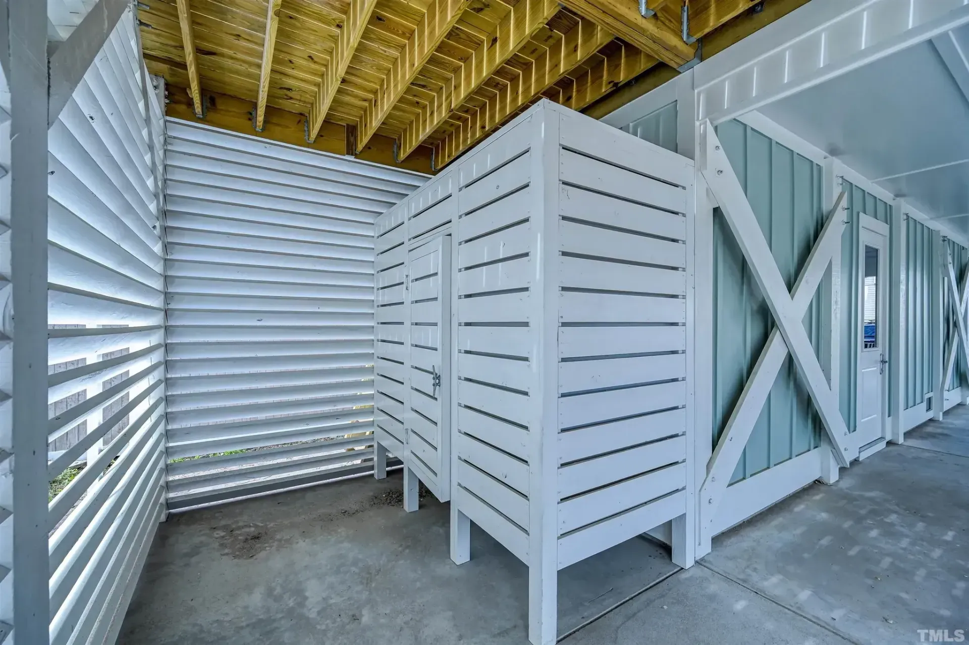 White slatted storage bins in an open attic-like industrial space with exposed roof beams
