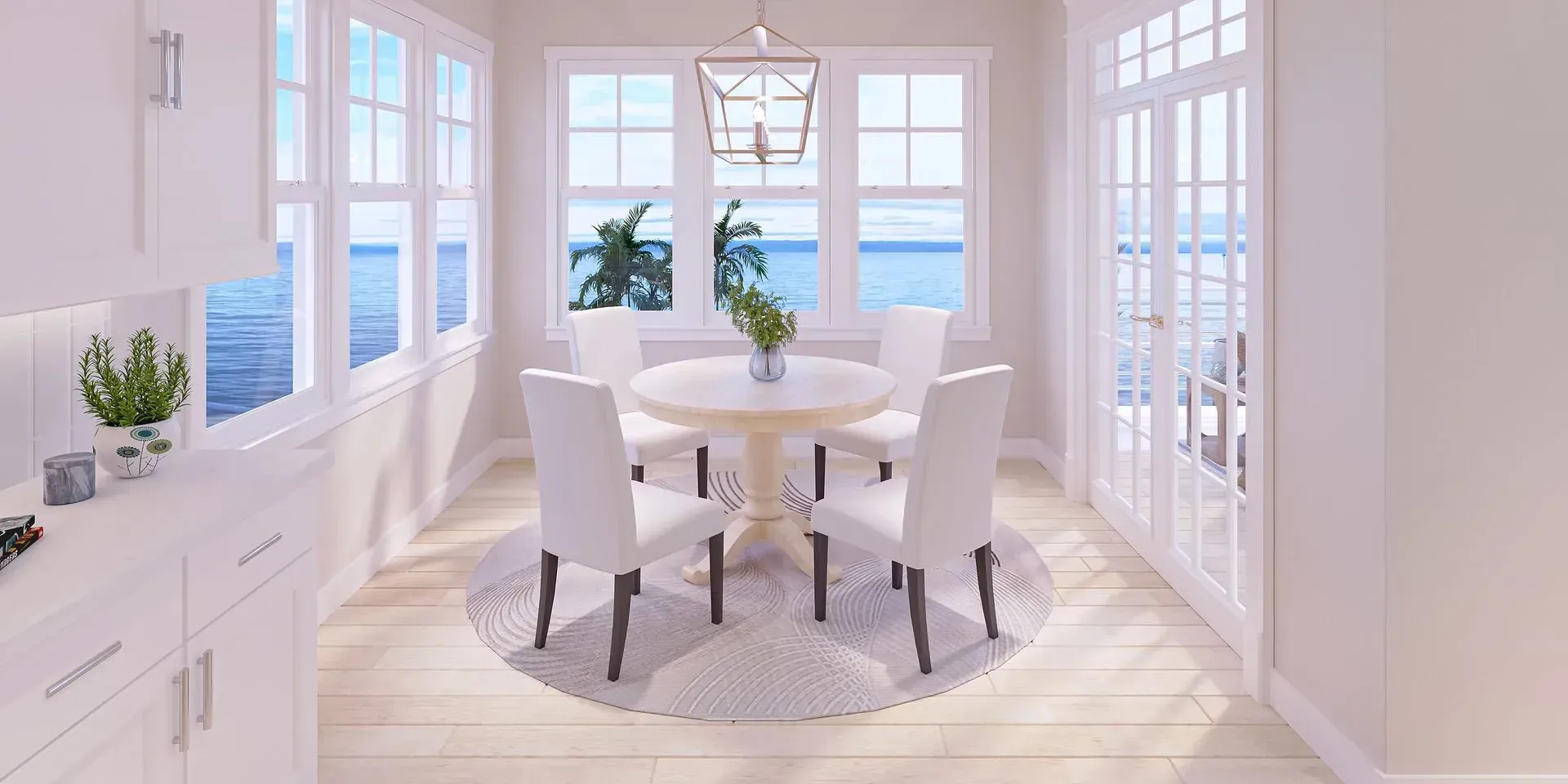A sunlit breakfast nook with a white round table, four white chairs on a round rug, and windows overlooking the ocean.