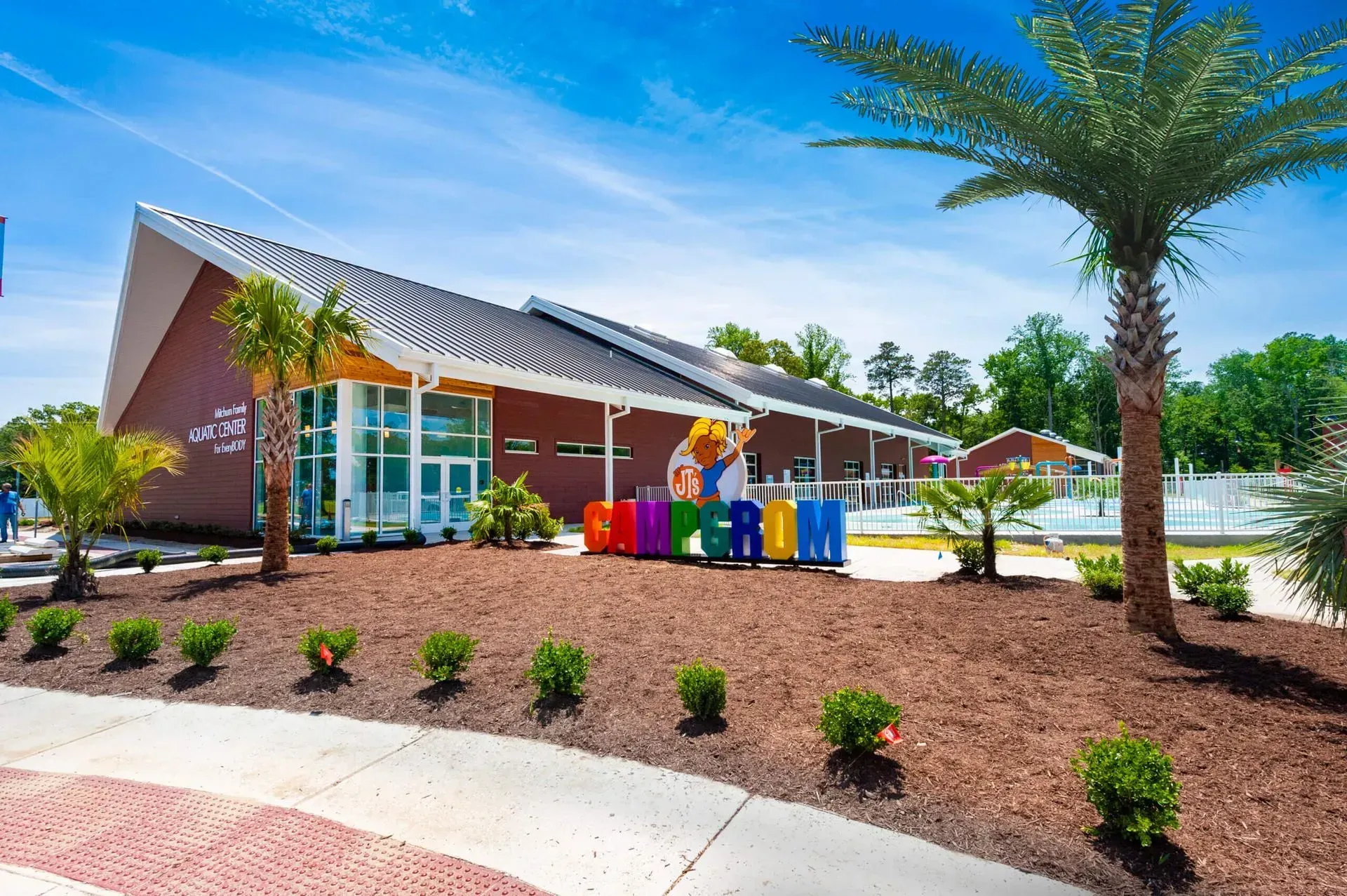 A modern building with a sloped roof, large windows, and a colorful 