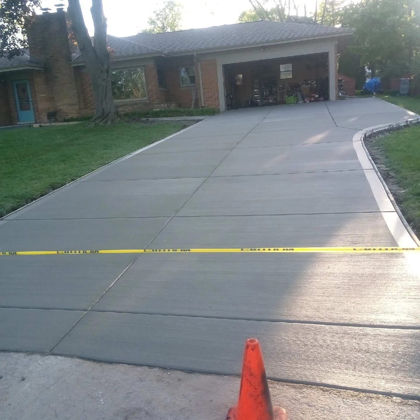 A concrete driveway with a yellow tape on it
